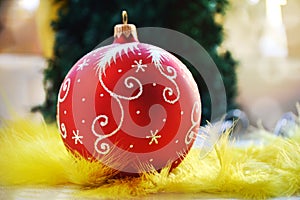 Red Christmas ball in soft yellow feathers.