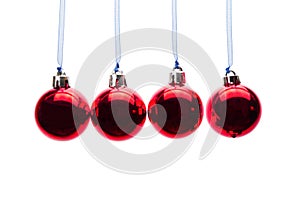 Red christmas balls hanging in a row on white background