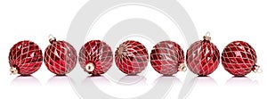 Red Christmas balls in a row side by side on a white