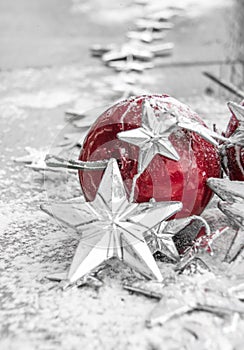 Red christmas balls on snow in front of white and sparkling background