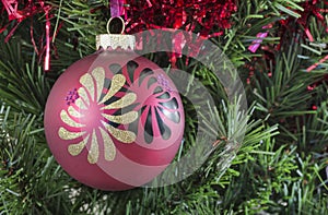 Red Christmas bauble hanging on a tree