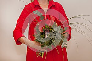 red christmas bouquet. womans hands with calla flower. decoration with bird, brunia and fir. holiday