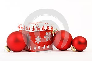 Red christmas box with red Christmas decoration and three red matt christmas balls on white background. Christmas box with christm photo