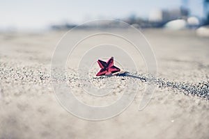 Red Christmas decoration forgotten in sand