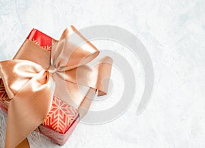 red christmas gift with golden bow on a white background