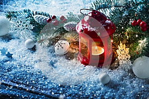 Red Christmas lantern in snow with fir tree branch. Winter cozy scene