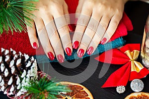 Red Christmas manicure make in beauty studio on Christmas background