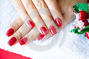 Red Christmas manicure make in beauty studio on Christmas background