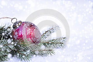 Red Christmas Ornament on Pine Branches and Snow