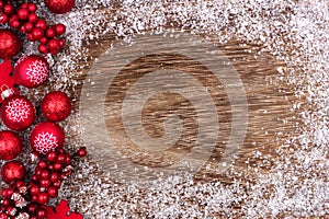 Red Christmas ornament side border with snow on rustic wood