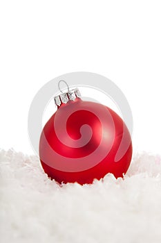 A red Christmas ornament in snow