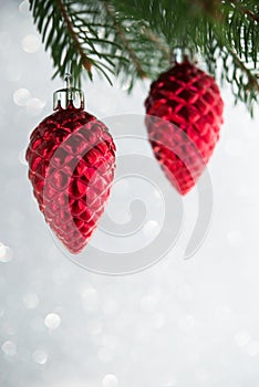 Red christmas ornaments cones on the xmas tree on glitter bokeh background.