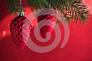 Red christmas ornaments cones on the xmas tree on red background.