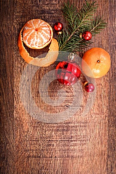 Red Christmas ornaments, food decor and fir tree branch on a rustic wooden background. Xmas card. Happy New Year