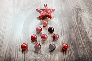 Red Christmas ornaments in the form of a Xmas tree on a rustic wooden background