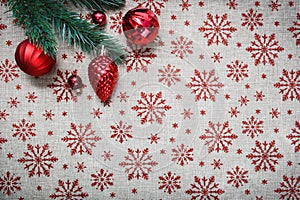 Red Christmas ornaments and xmas tree on canvas background with red glitter snowflakes. Xmas card. Happy New Year