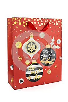 Red Christmas shopping bag made of paper decorated with Christmas balls on a white background. New year and gifts concept