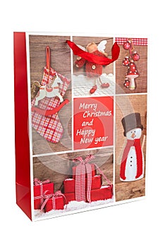 Red Christmas shopping bag made of paper decorated with snowman and presents on a white background. New year and gifts concept