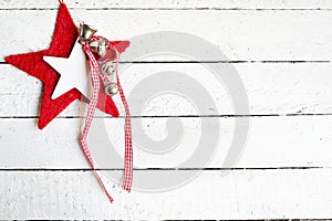 Red christmas star with bells on white wooden background, copy space