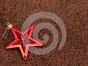 Red Christmas Star Ornament Shining Against a Rich Brown Backdrop