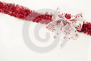 Red christmas tinsel with bow isolated on white background