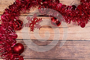red christmas Tinsel and String Lights Border on wooden Background