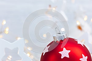 Red christmas tree ball on blurred garland lights background