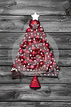 Red christmas tree with balls on old wooden shabby background.