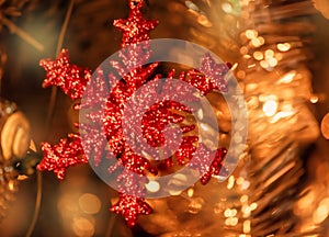 Red Christmas tree toy in the form of snowflakes, tinsel and shining garlands on a dark background. New Year 2021. Selective focus