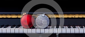 Red Chritmas balls on piano keyboard, front view