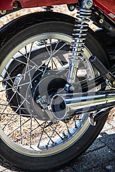 Red chrome motorcycle with spokes, exhaust and shock absorber