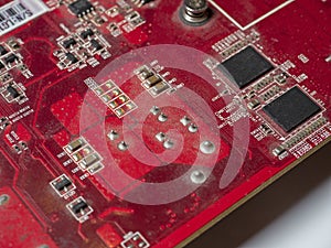 Red circuit board with chips and capacitors. Electronic board close-up