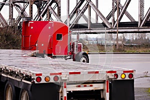 Red classic big rig truck old bridge flat beds turning on road