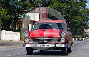 A red classic car drived on the street in havana city