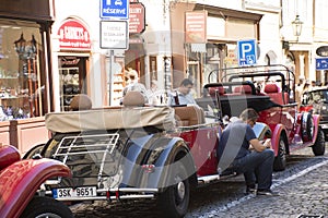 Red classic retro car for people and travelers take photo at old town near Charles Bridge