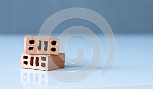 Red clay bricks isolated on a white surface with a grey background with copy space