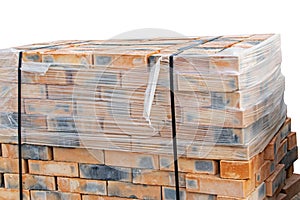 Red clay bricks are stacked on white