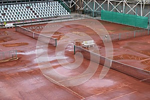 Red clay tennis court wet after rain