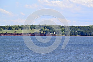 Red cliff and pair of lighthouses on far shore of Charlottetown Harbour