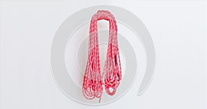 Red climbing rope coil sways gently from side to side. This rope is coiled using the single butterfly coil method