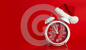 Red clock with Christmas Santa hat. Time for Christmas shopping concept. Blank red space for text