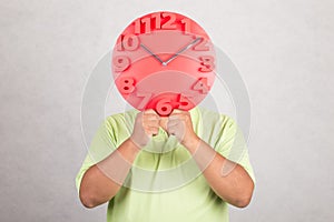 Red clock in front of head.