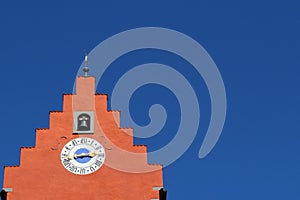 Red clock tower against blue sky-landscape format