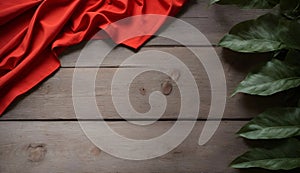 Red Cloth on a Rustic Wooden Table with Green Leaves, Copy Space