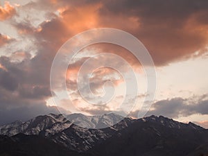 Red clouds sunset over snowy mountains