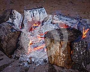 Red coal and fire flames in the middle of the campfire