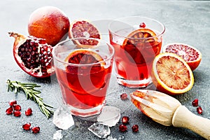 Red cocktail with blood orange and pomegranate. Refreshing summer drink. Holiday aperitif for Christmas party.