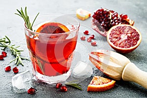 Red cocktail with blood orange and pomegranate. Refreshing summer drink. Holiday aperitif for Christmas party.