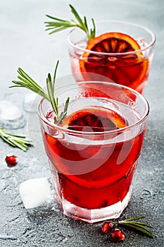 Red cocktail with blood orange and pomegranate. Refreshing summer drink. Holiday aperitif for Christmas party.