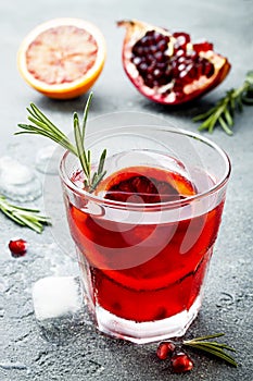 Red cocktail with blood orange and pomegranate. Refreshing summer drink. Holiday aperitif for Christmas party.